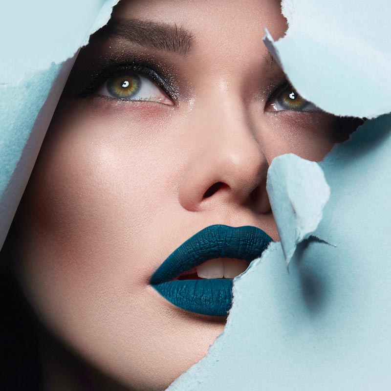 A cosmetic model appears through a blue sheet