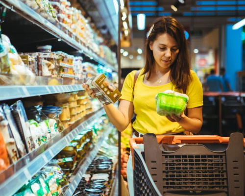 A woman in a retail store is deciding between two different products.